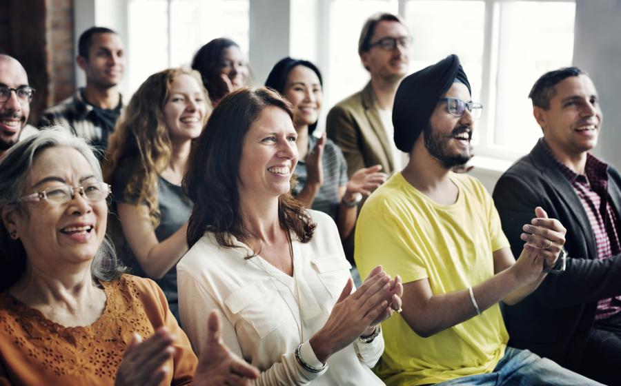 Room full of diverse people applauding