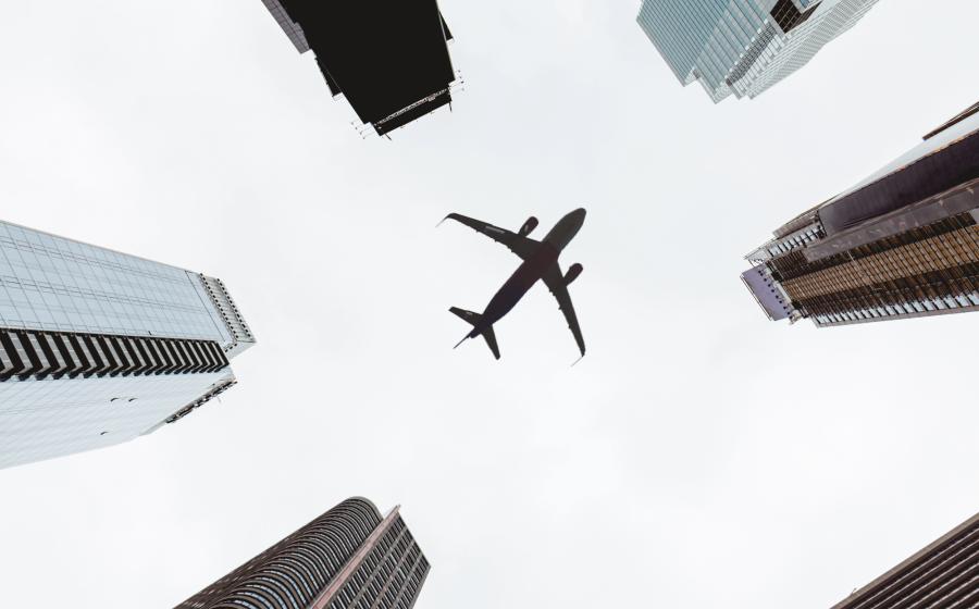 airplane flying over skyscrapers in NYC