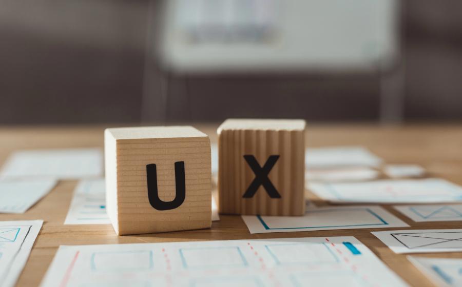 Selective focus of cubes with ux letters and designer app sketches on table