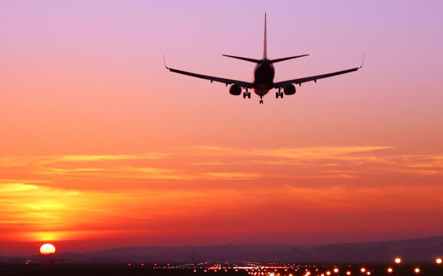 Airplane taking off into the sky at sunset