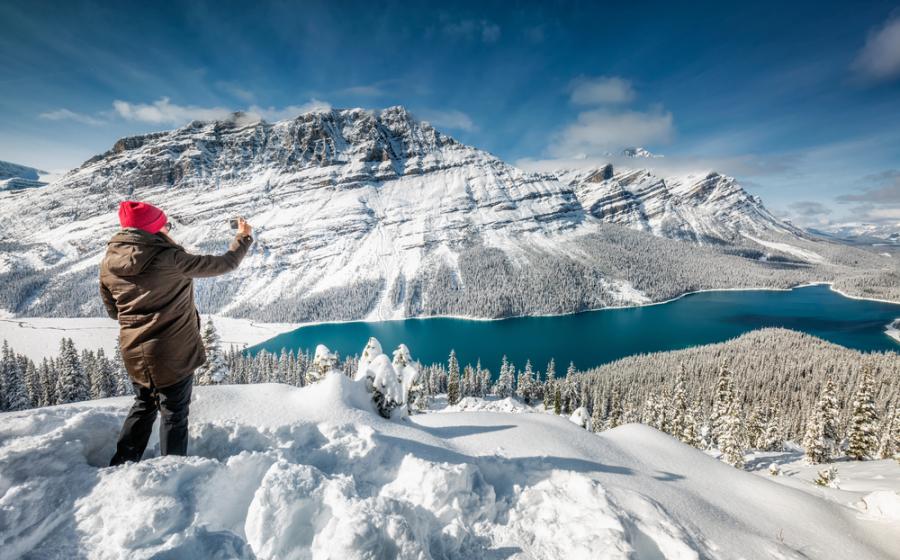 Woman taking a photo in the snow at Banff National Park