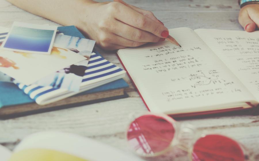 woman writing in travel journal