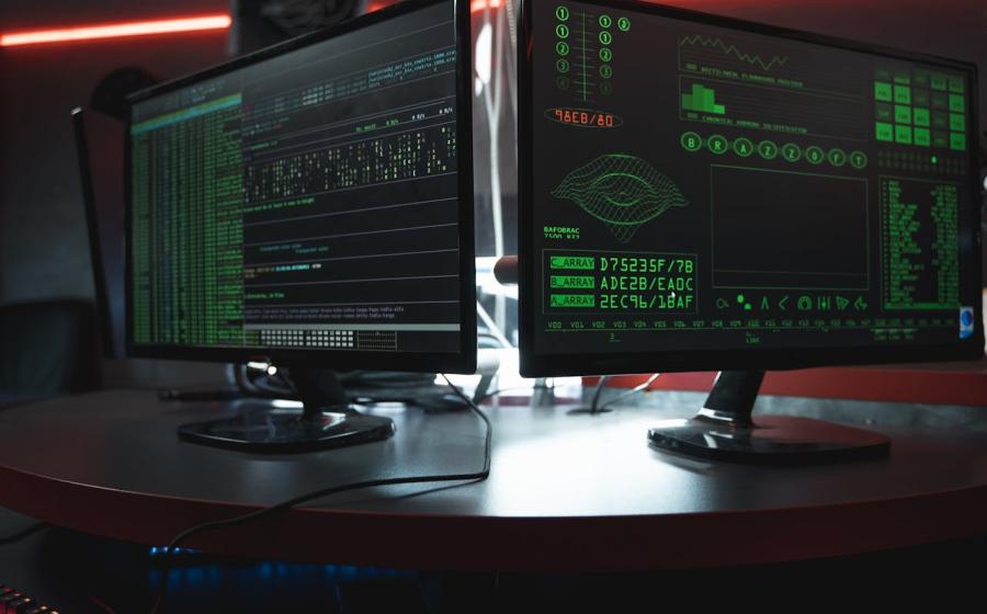 Two computer monitors with cybersecurity work