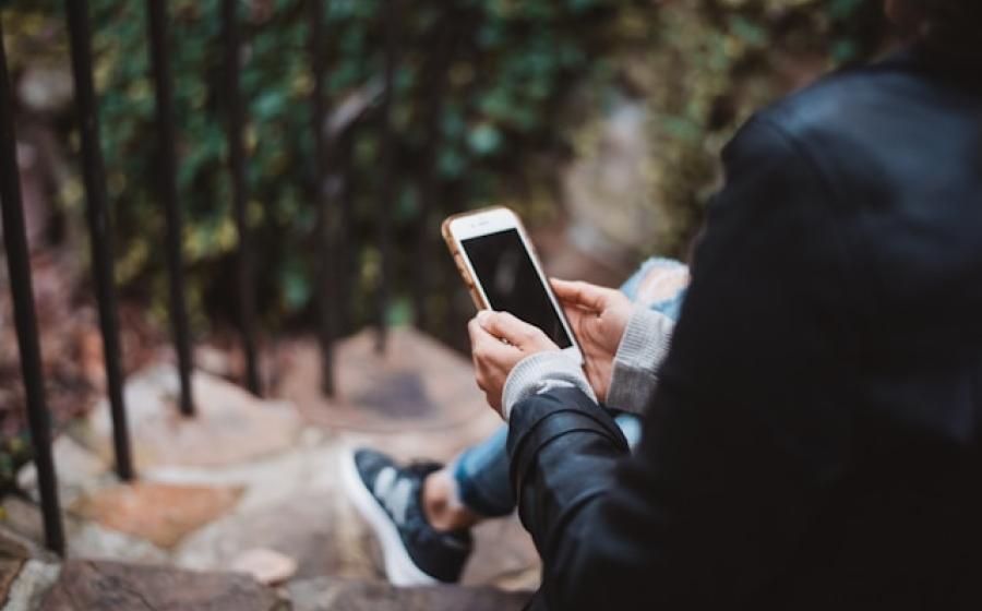 Person in a business suit looking at a cellphone