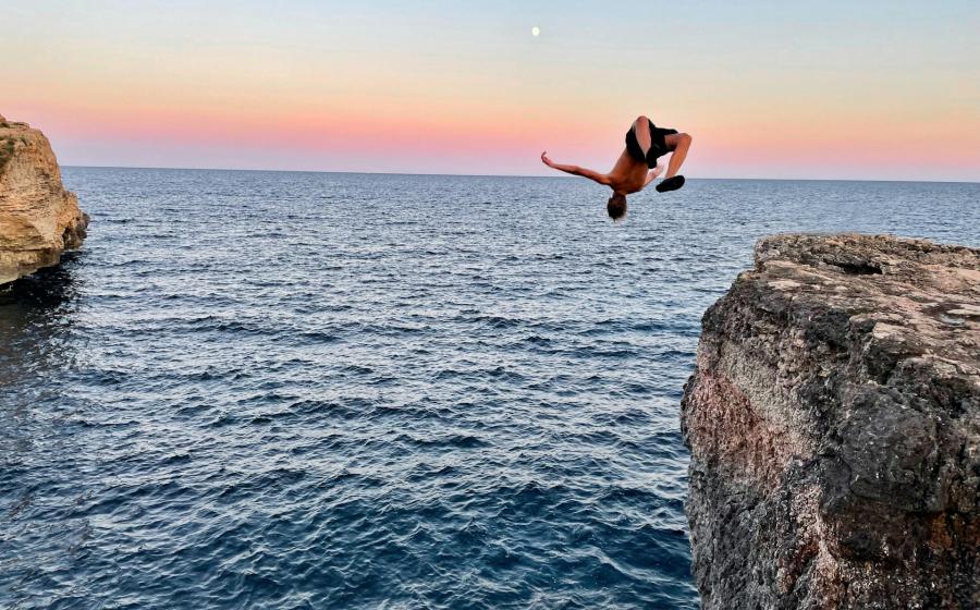Person leaping off a cliff into the water