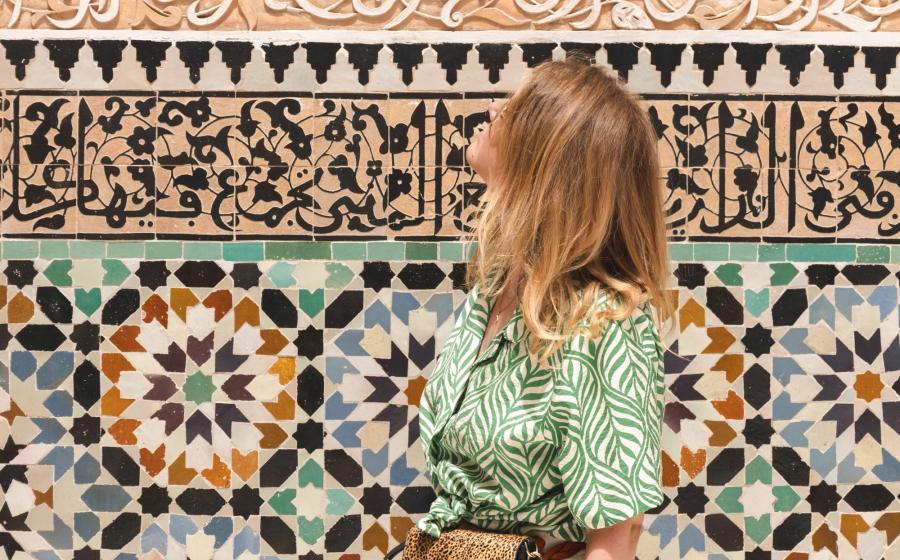 traveler in front of a colorful mosaic wall