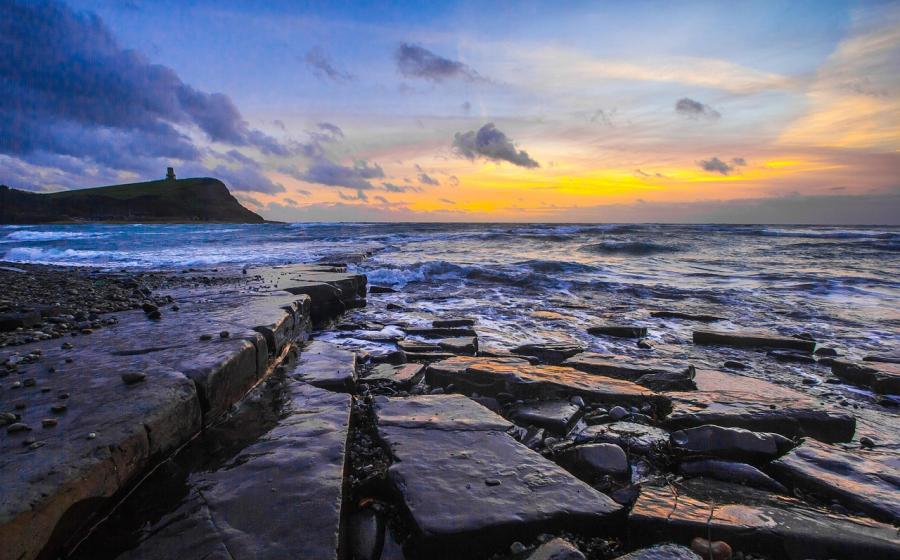 Sunset with rocks, cliffs, and sea