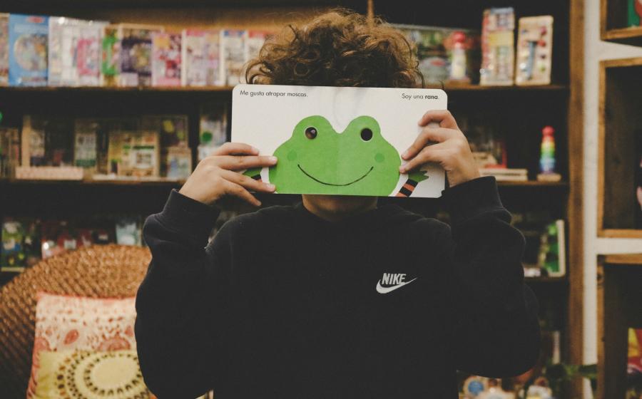 kid holding a book with a frog on it!
