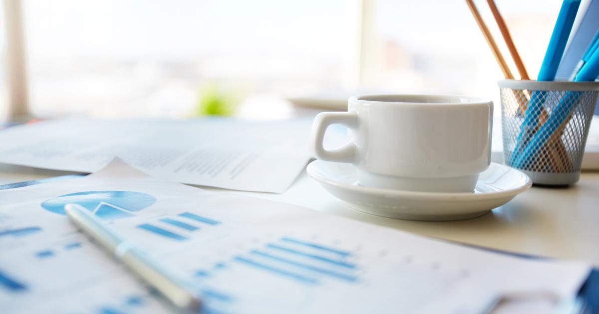 financial spreadsheets and a cup of coffee