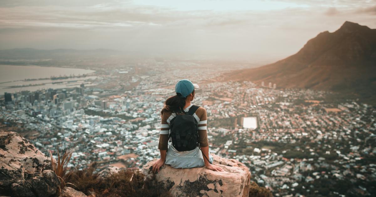 woman on mountaintop above city
