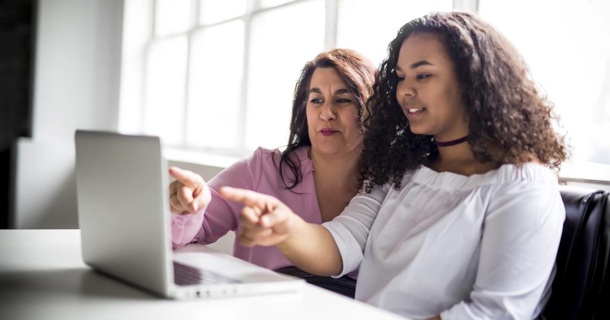 mom and daughter looking at laptop